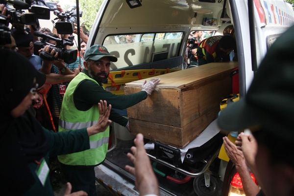 Pakistani rescue personnel load coffin of foreign climber into ambulence.  Farooq Naeem / AFP - Getty Images Pakistani rescuers move a coffin of a foreign tourist from an ambulance to a hospital in Islamabad on June 23.