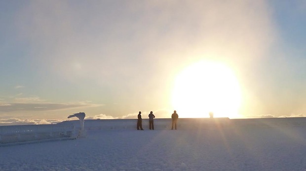 Our Summit Interns, Tom Padham and Sam Hewitt, take in a sunrise atop the rime- and snow-covered observation deck, along with Director of Summit Operations Cyrena Briedé. - Mt. Washington Observatory