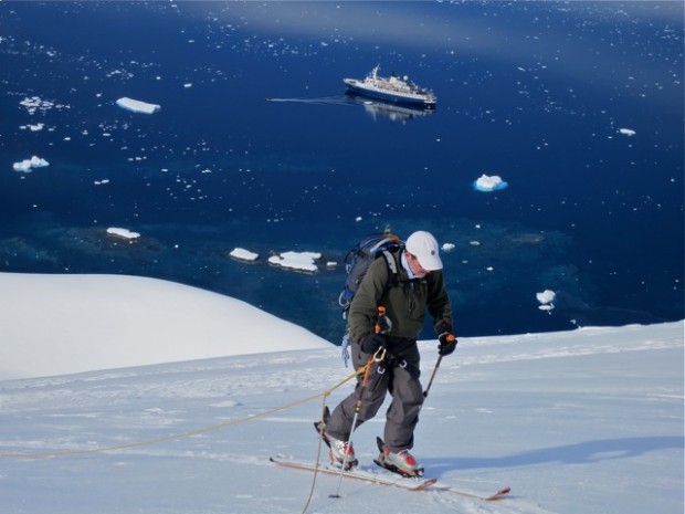 Client Bruce Cummings skinning up the glacier with the Sea Adventurer below.  photo:  Chris Davenport