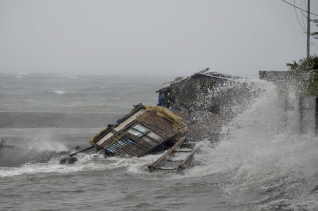 A house is engulfed by the storm surge brought about by powerful typhoon Haiyan that hit Legazpi city, Albay province Friday Nov.8, 2013.  photo:  huffington post