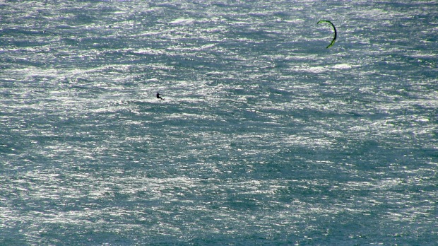 Kite surfer and oceanic shimmer.