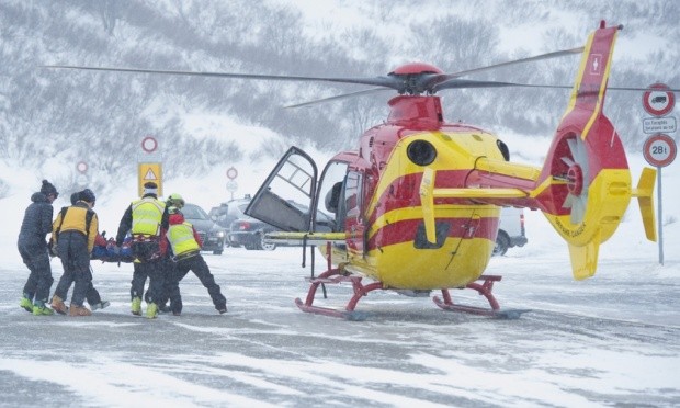 Rescuers carry a skier to a helicopter near the Grand Saint Bernard pass on Saturday. Photograph: Maxime Schmid/AP