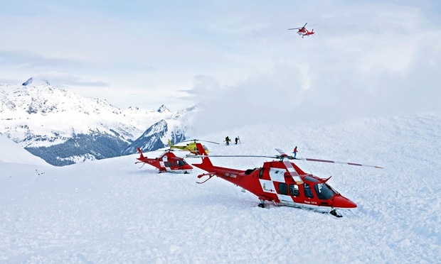 Rescue helicopters and rescue workers on duty after avalanche accident at the Piz Vilan mountain. Photograph: REGA / HANDOUT/EPA
