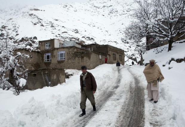 Afghan men walk in a village close to an avalanche site in Panjshir province north of Kabul, Afghanistan, Wednesday, Feb. 25, 2015. (AP Photo/Massoud Hossaini)