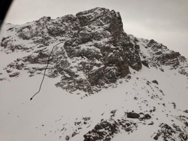 The upper portion of the couloir is mostly out of view but the hanging snowfield can be seen. The avalanche carried the skier over the cliffs. Photo: GNFAC