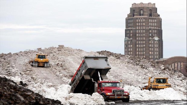 Dump trucks pile snow at Buffalo's Central Terminal on Sunday, November 23, 2014 after a lake effect snow storm brought over seven feet of snow 