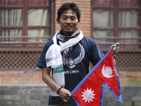 Nobukazu posing with the Nepali flag at a press conference in Katmandu. photo: AP Photo/Bikram Rai