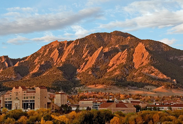 This sunrise photo of CU Boulder against the backdrop of the Boulder Flatirons was taken in the fall from a hotel balcony in north Boulder. Founded in 1876, the CU Boulder campus spreads across more than 600 acres with many old stone buildings featuring red Spanish tiled rooftops.