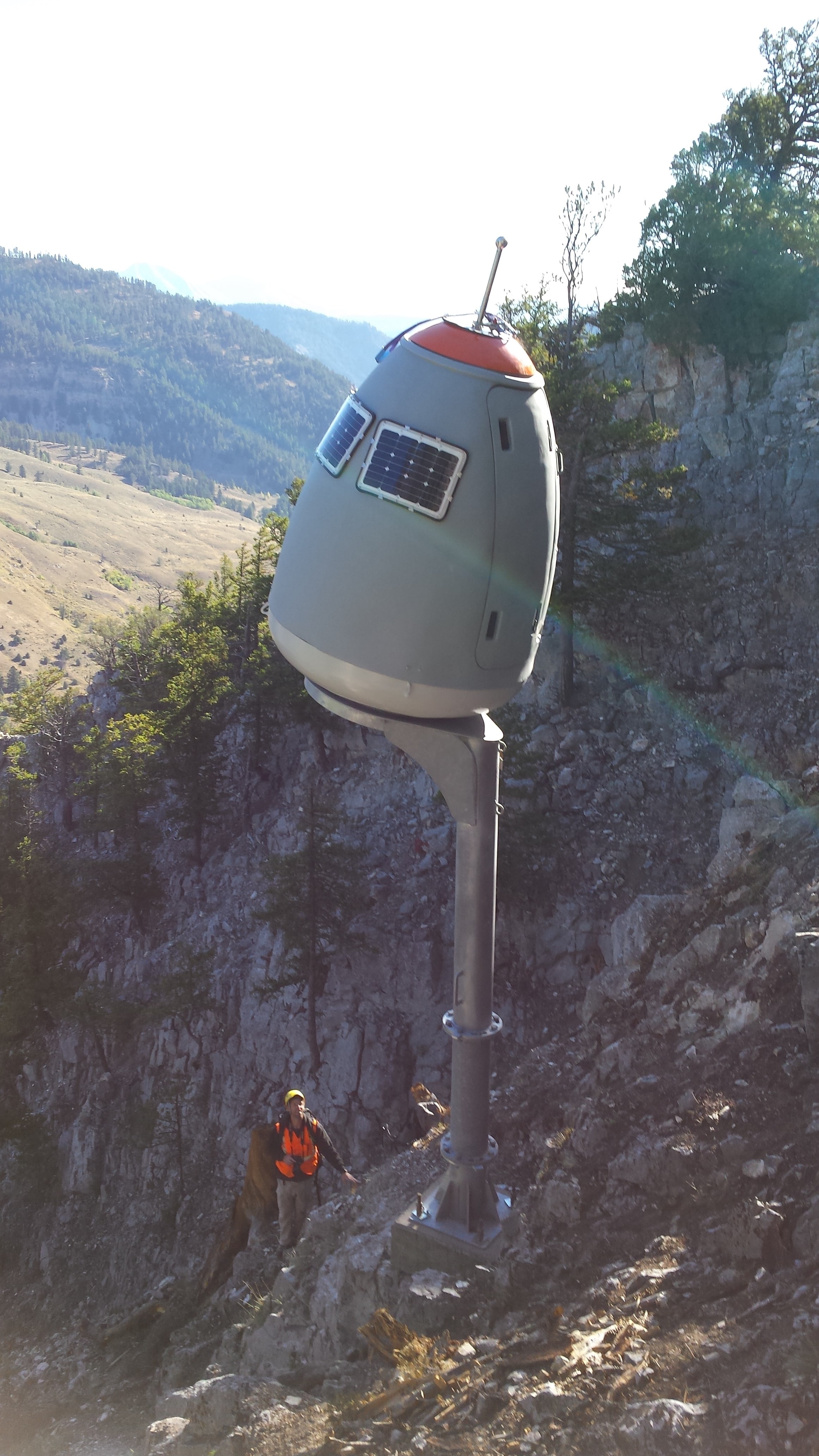 The O’Bellx exploder dwarfs a worker in the Cow of the Woods avalanche path in the Hoback Canyon. The device enables an operator to set off an explosion to provoke an avalanche while safely protected from the snowslide far away. The new contraptions can be removed, serviced, and replaced by helicopter. (WYDOT)