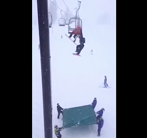 snowboarder falls from chairlift