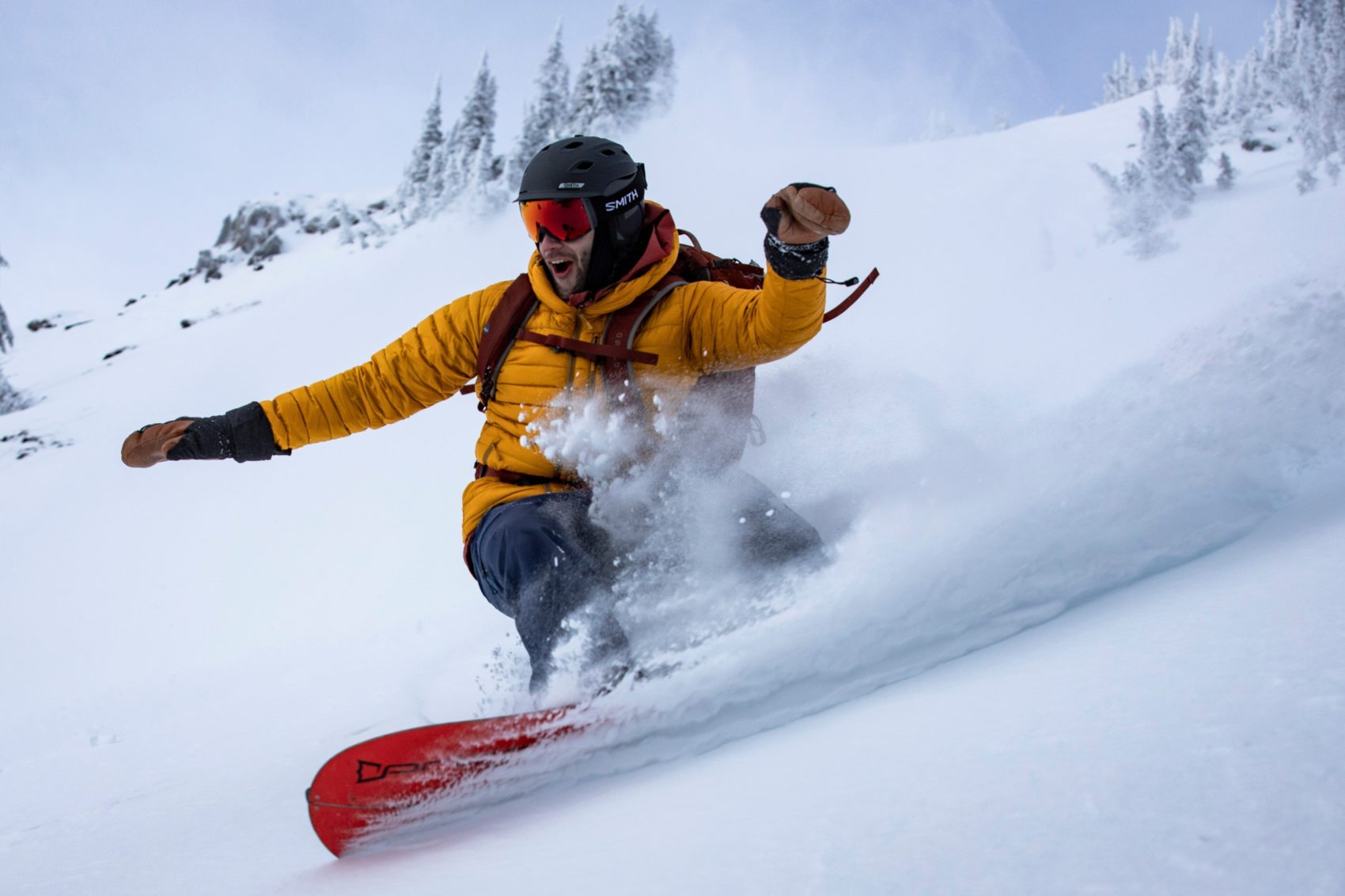 snowboarder slashing powder in revelstoke