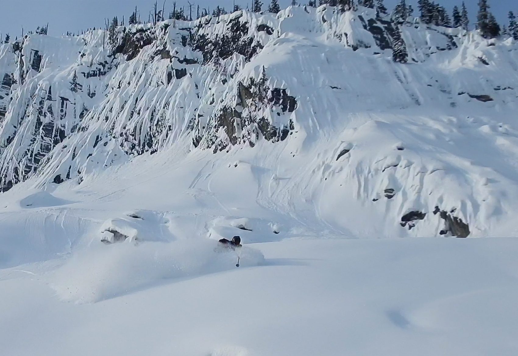 skier slashing through powder overhead