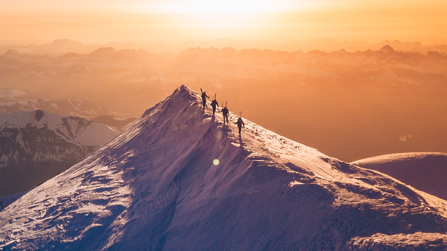 hikers climb peak in winter with back country skis