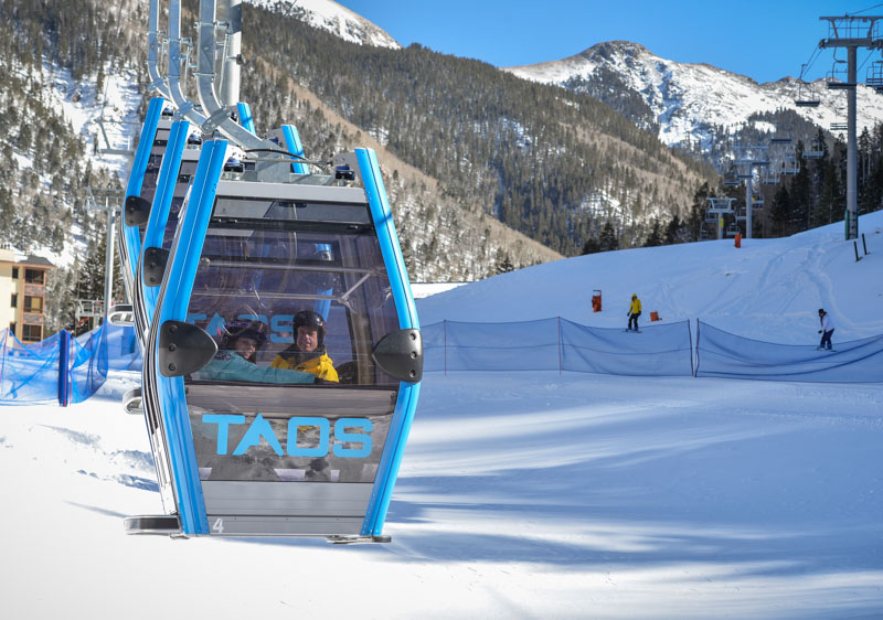 people riding taos ski lift, app