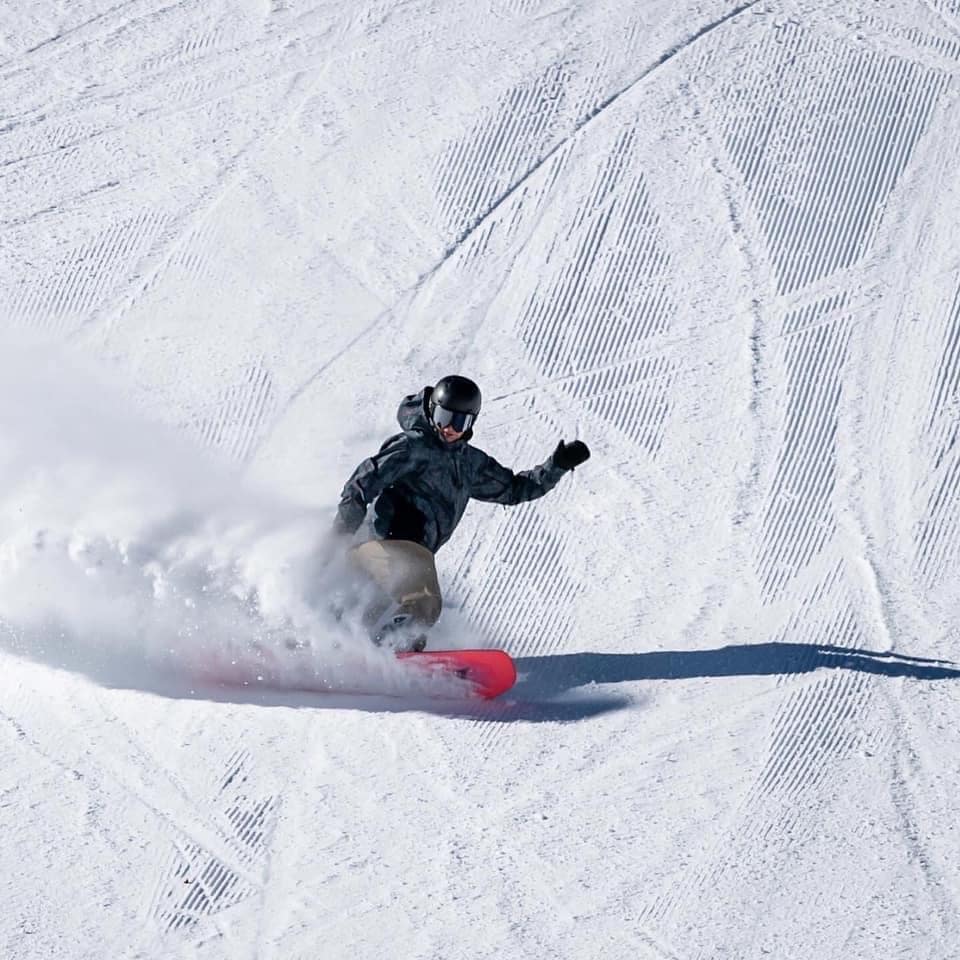 Snowboarder carving on a groomer at Palisades Tahoe
