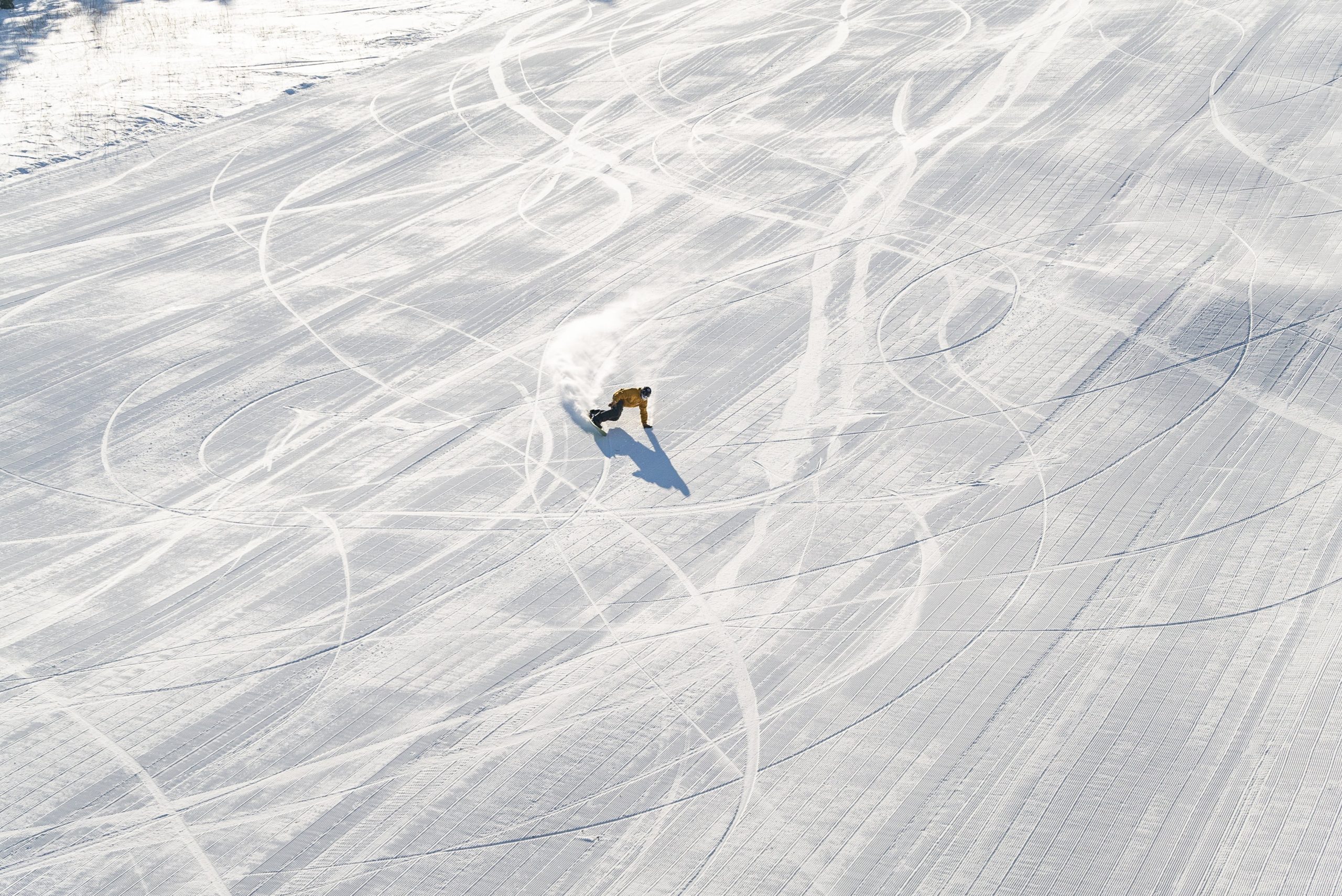 Snowboarder carves empty groomers