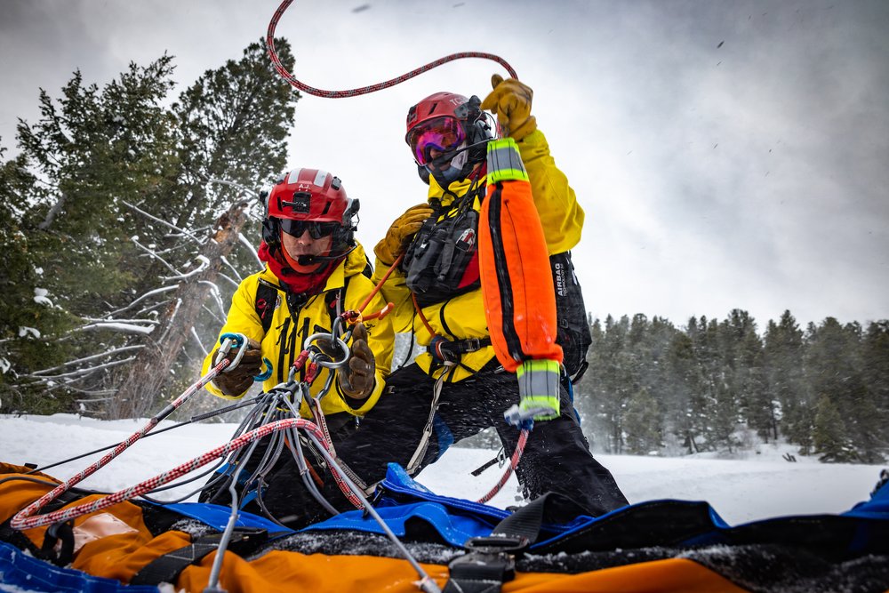 TCSAR volunteers above patient, and below helicopter