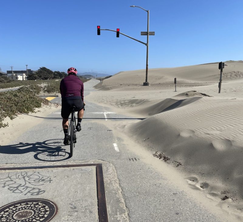 A highway turned pedestrian path due to the winds bringing in large amounts of sand. Photo Credit: Luke Guilford
