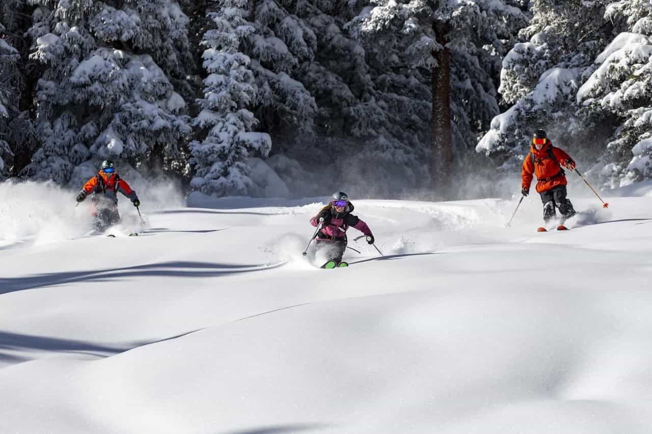 Aspen Snowmass Hero's terrain skiers in fresh deep powder snow