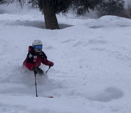 Ski patroller skiing through deep powder