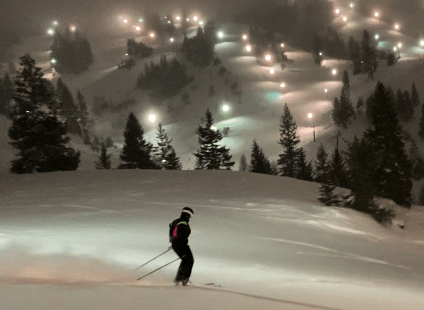 night skiing in powder with views of the lights of the ski resort