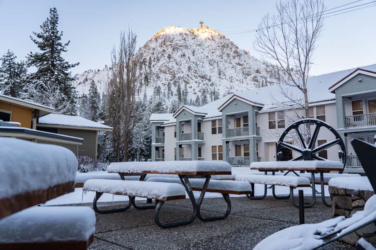 fresh snow on outdoor seats and tables with mountain in the background