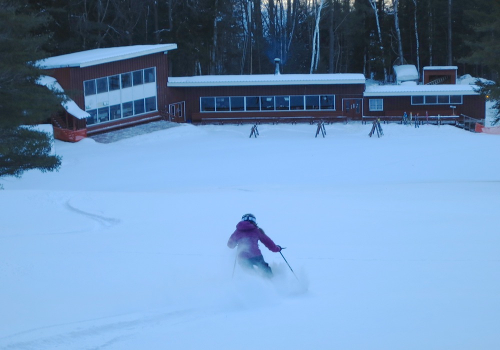 skier in fresh snow in front of the Hickory base area
