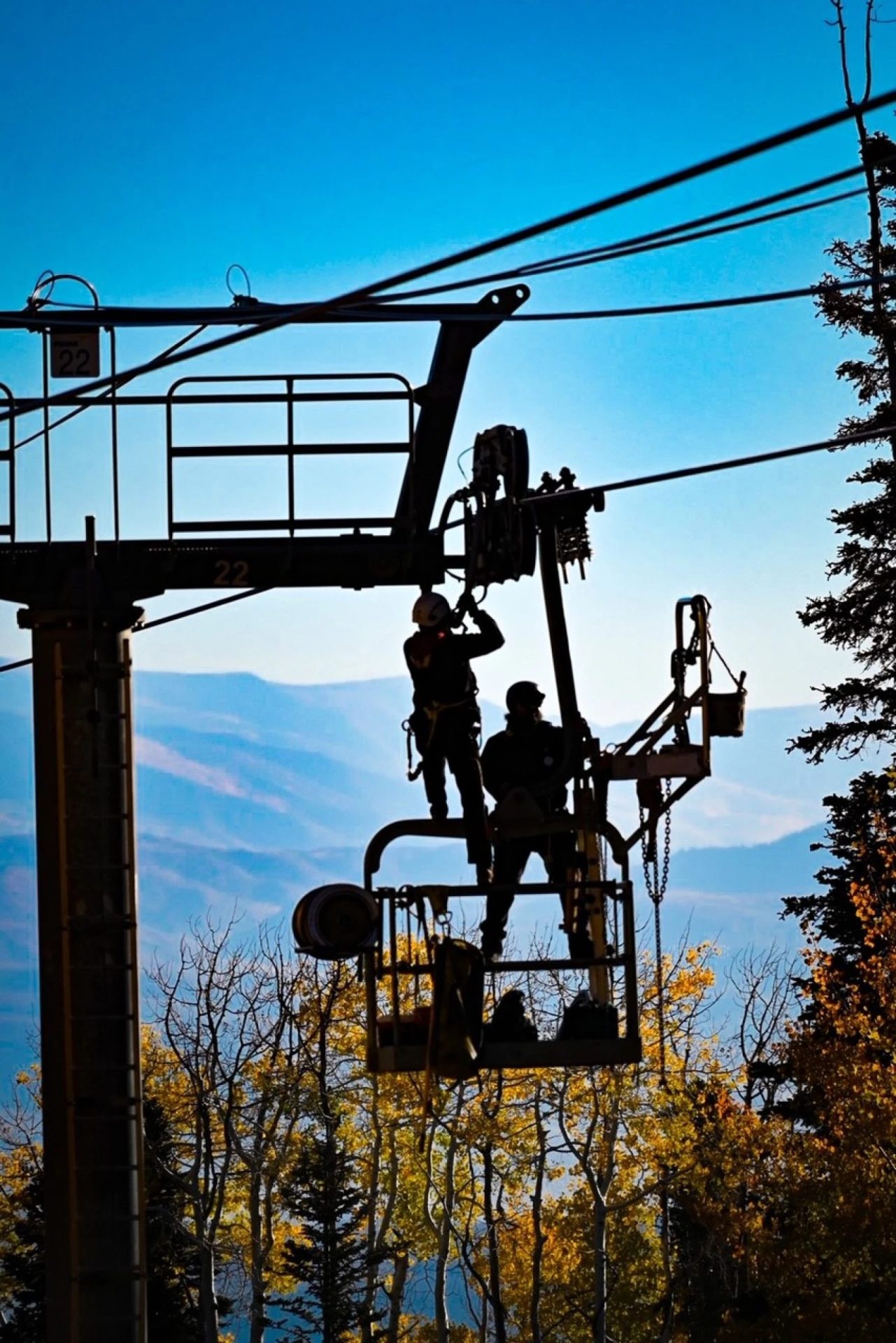 lift mechanics servicing chair lift with ropes