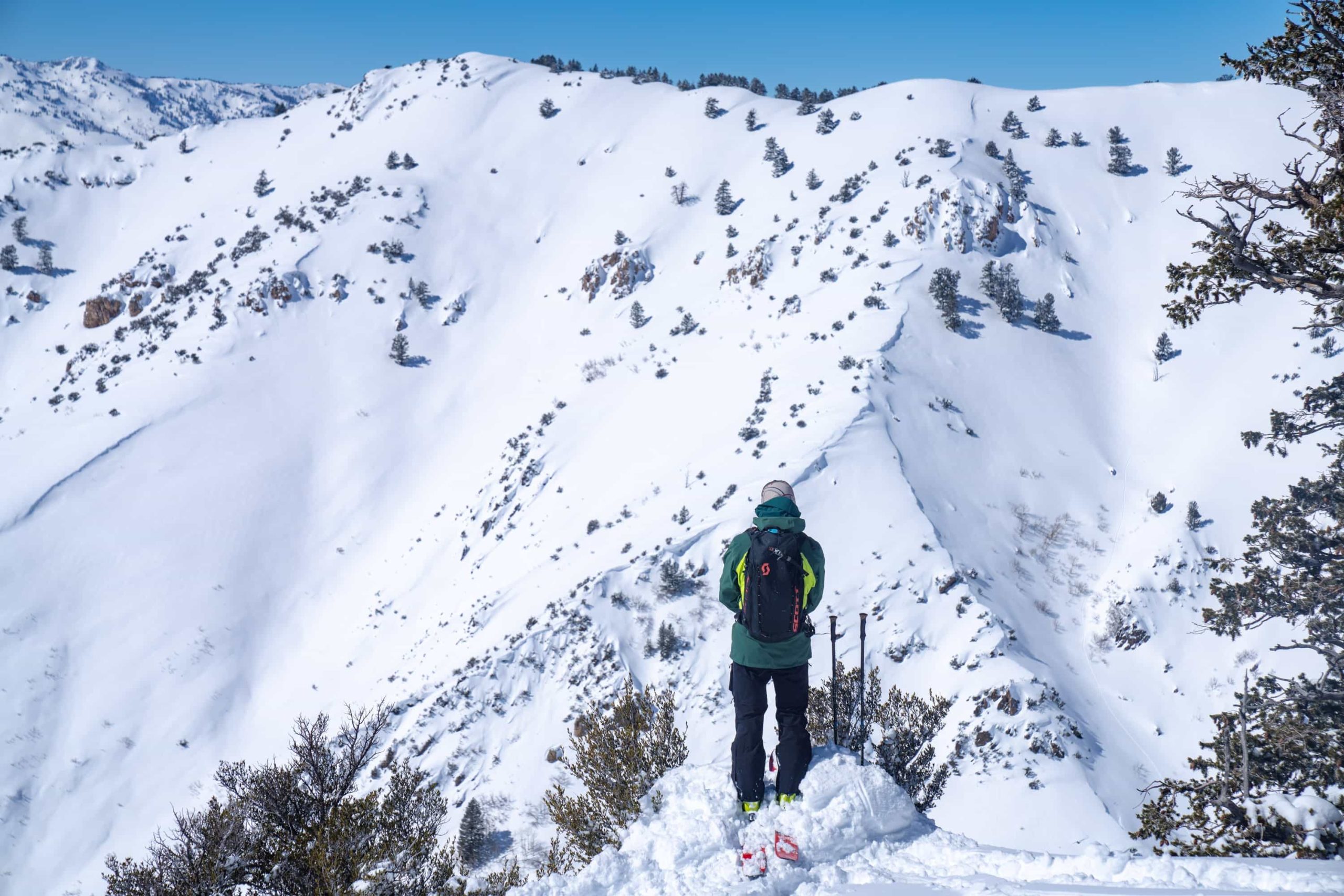 esquiador olhando para uma montanha nevada com céu azul