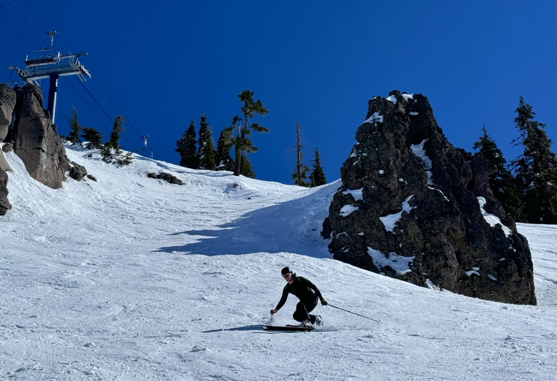 telemark skier dropping a knee on the exit of a rock chute