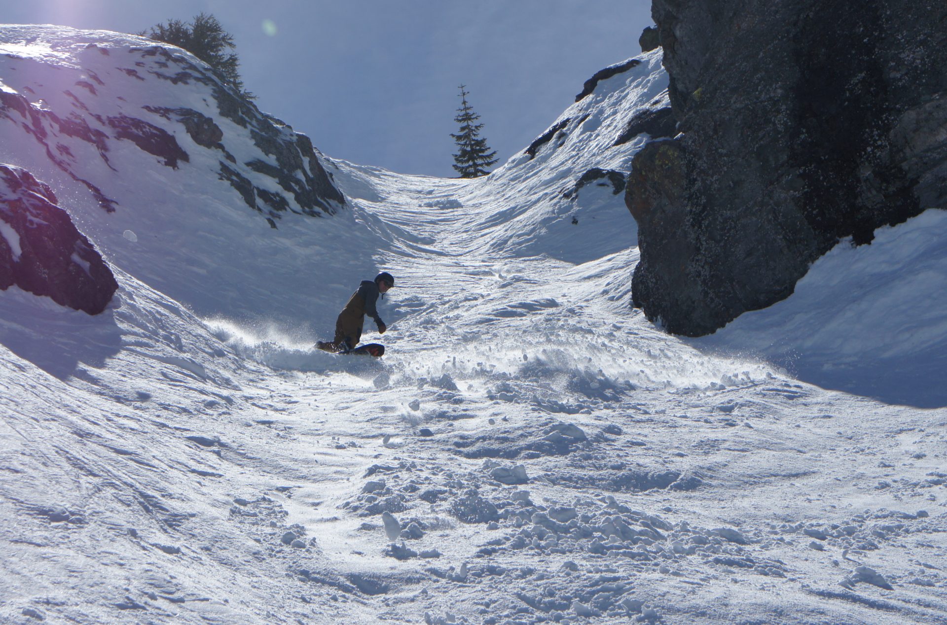 snowboarder in steep rock chute at palisades tahoe