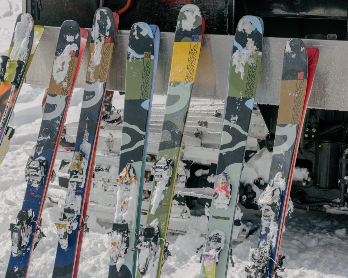 A lineup of K2 skis on a ski rack. 