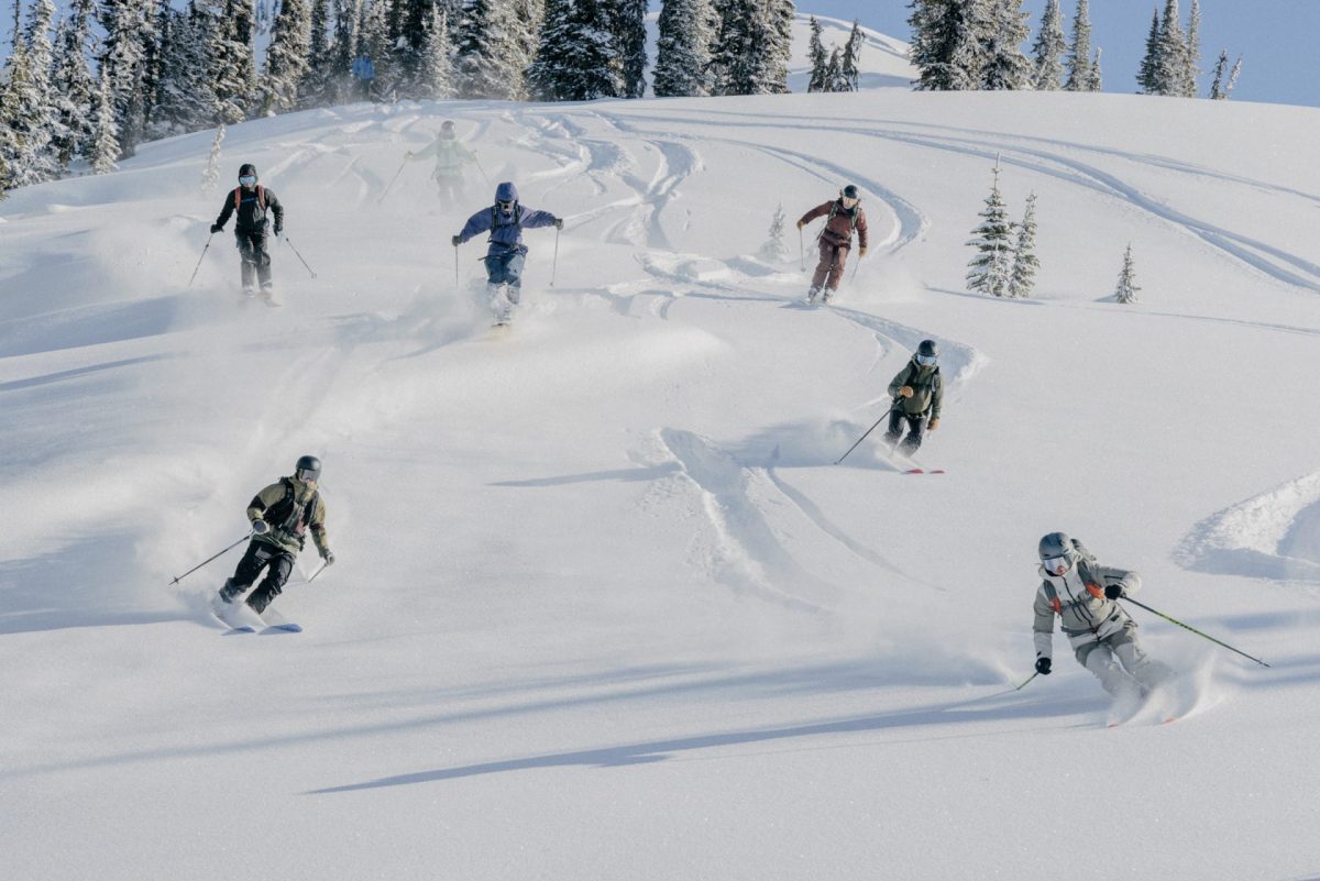 Friends ski together down a powdery slope.