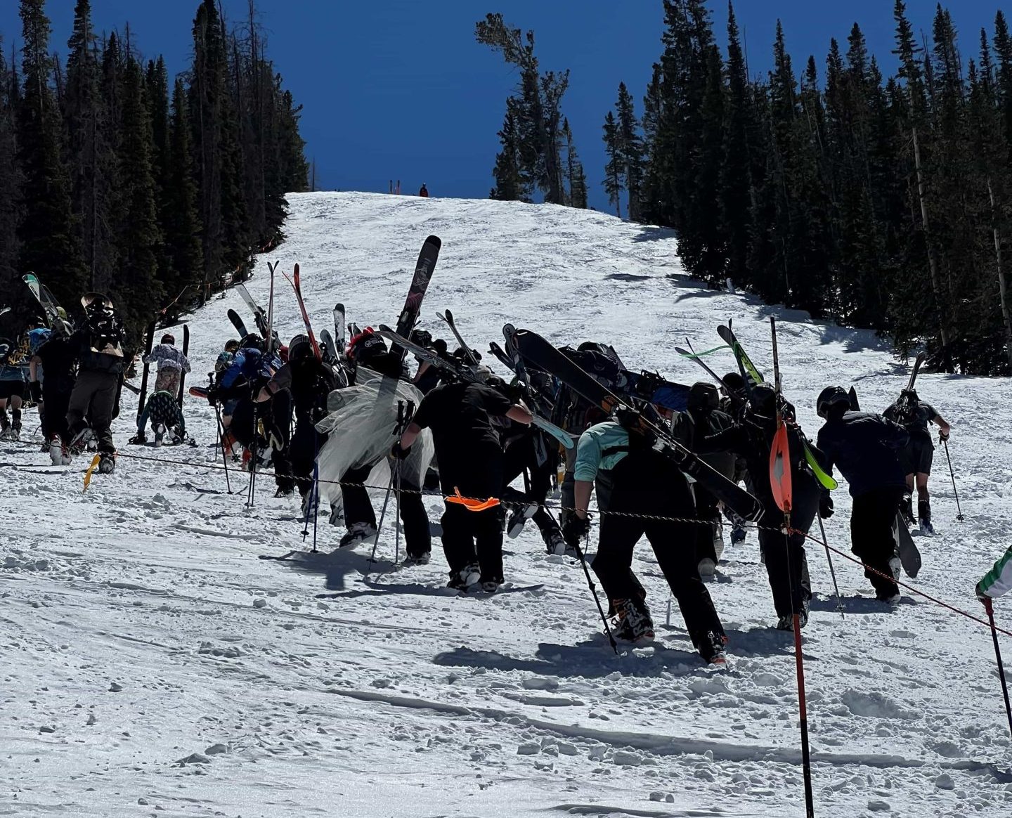 skiers and boarders bootlicking up snowy gunbarrel ski slope at monarch mountain colorado