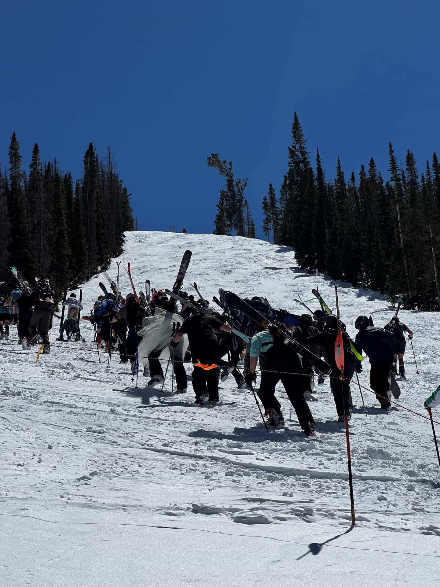 skiers and boarders bootlicking up snowy gunbarrel ski slope at monarch mountain colorado
