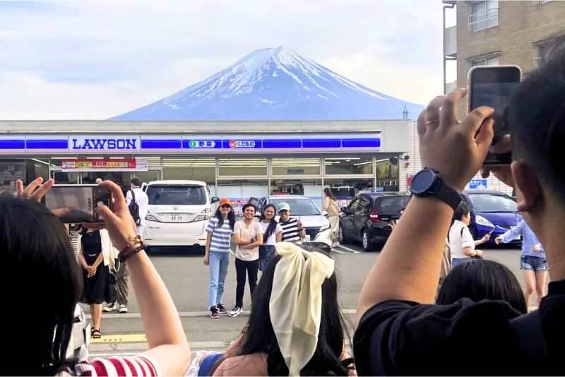 Japan's Battle Against Overtourism - Tourists taking photo of lawson