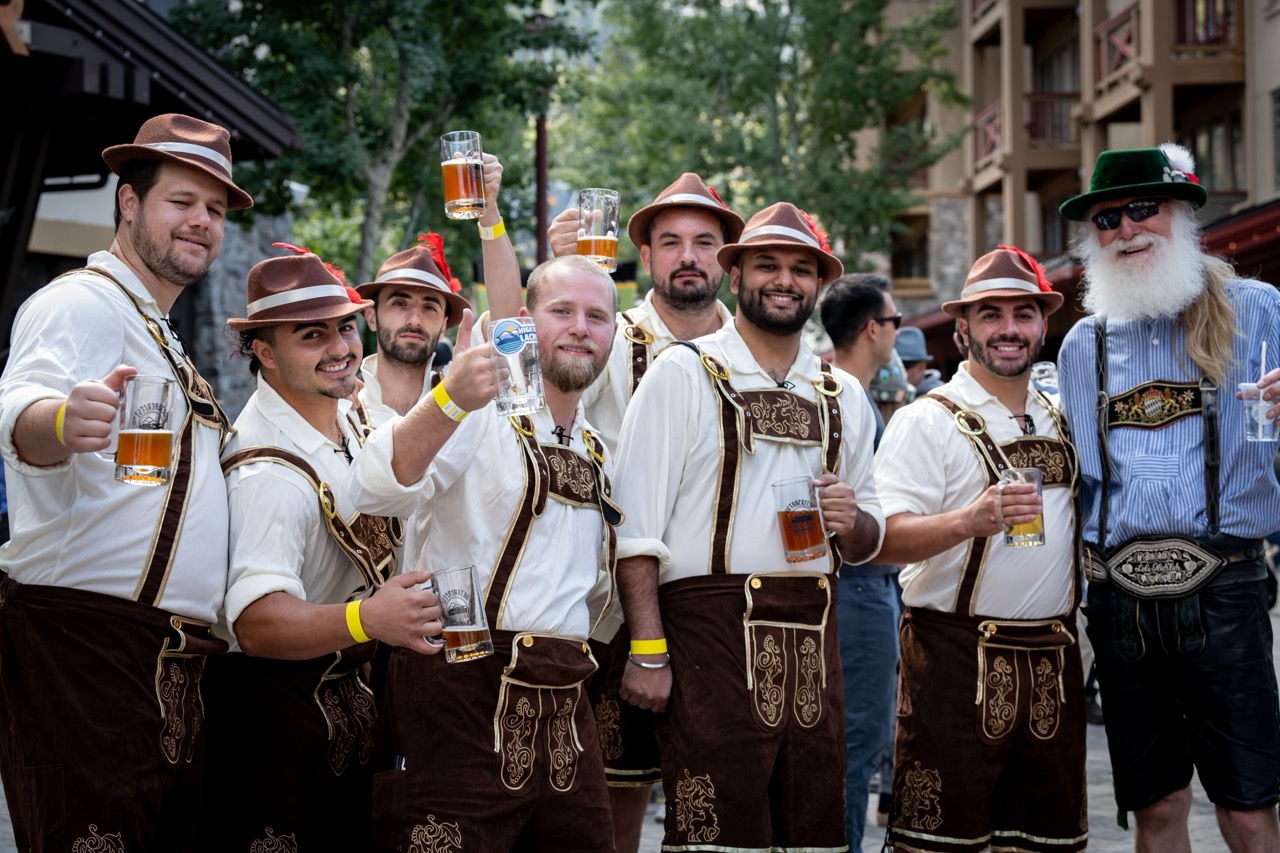 A group of men dressed in traditional german outfits drinking beer for Oktoberfest at Palisades Tahoe