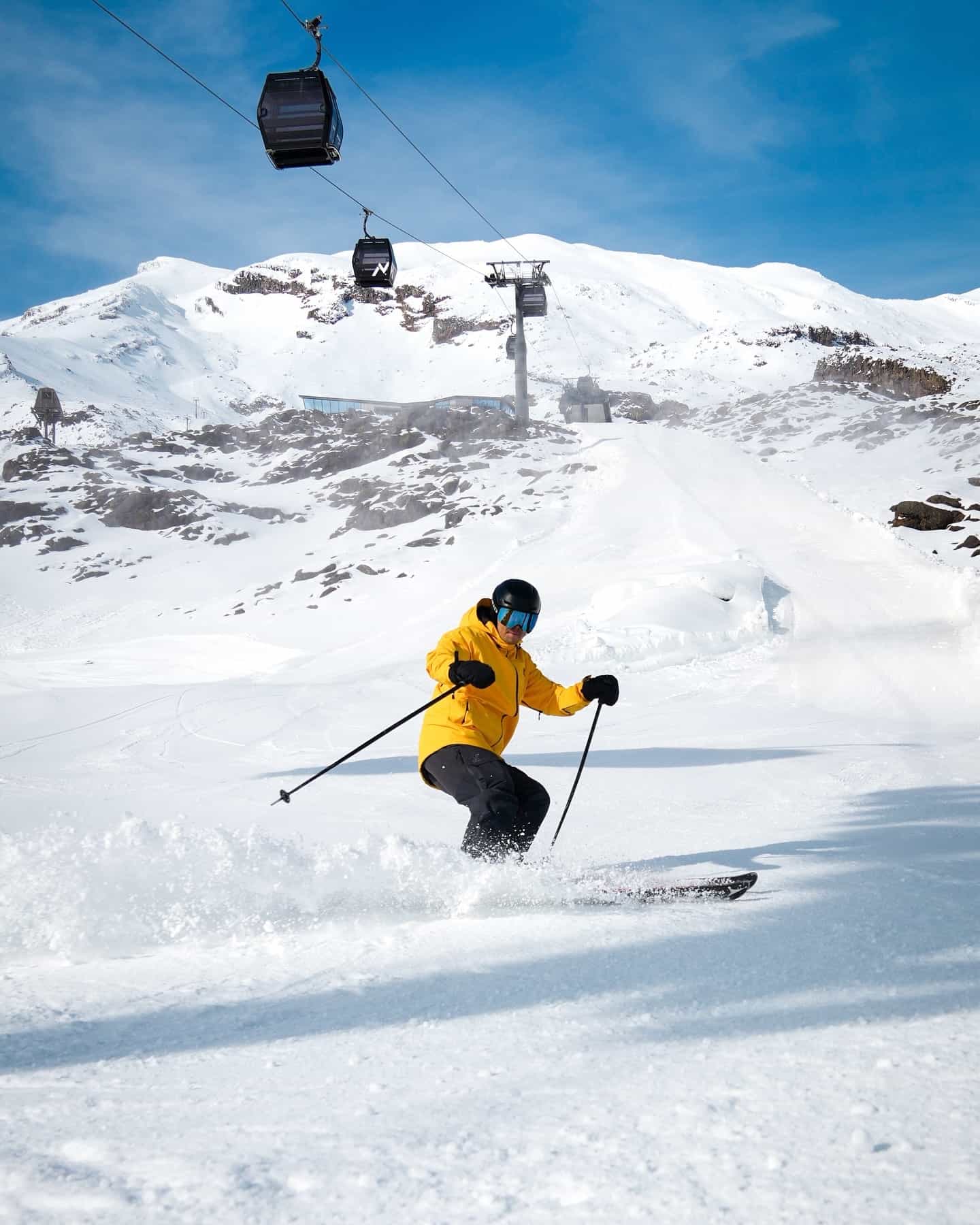 Skier in deep snow under chairlift at Whakapapa, New Zealand