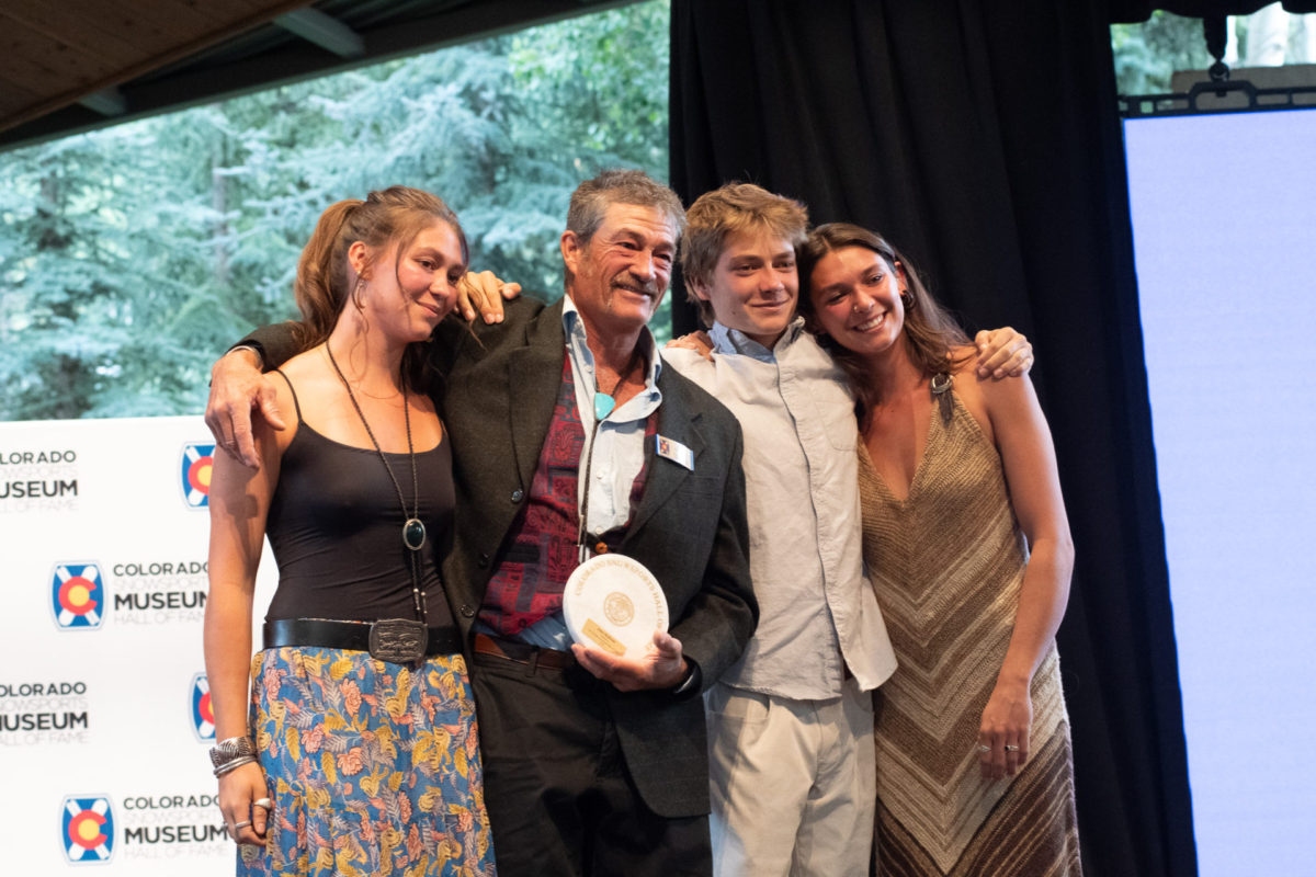 John McBride poses for a photo with his children after accepting his award.