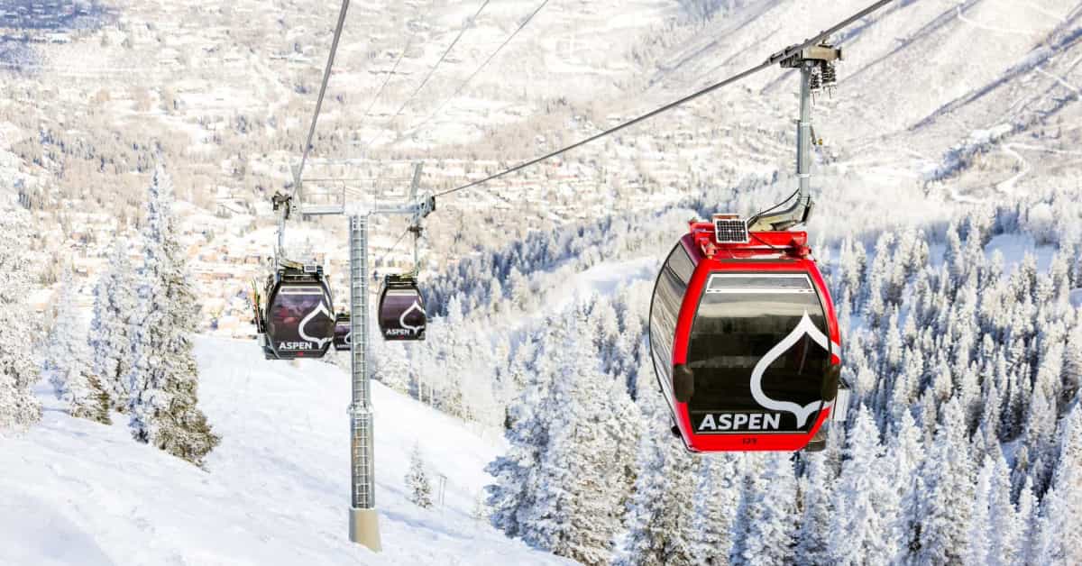 gondola at Aspen Snowmass above a snowy mountain and trees