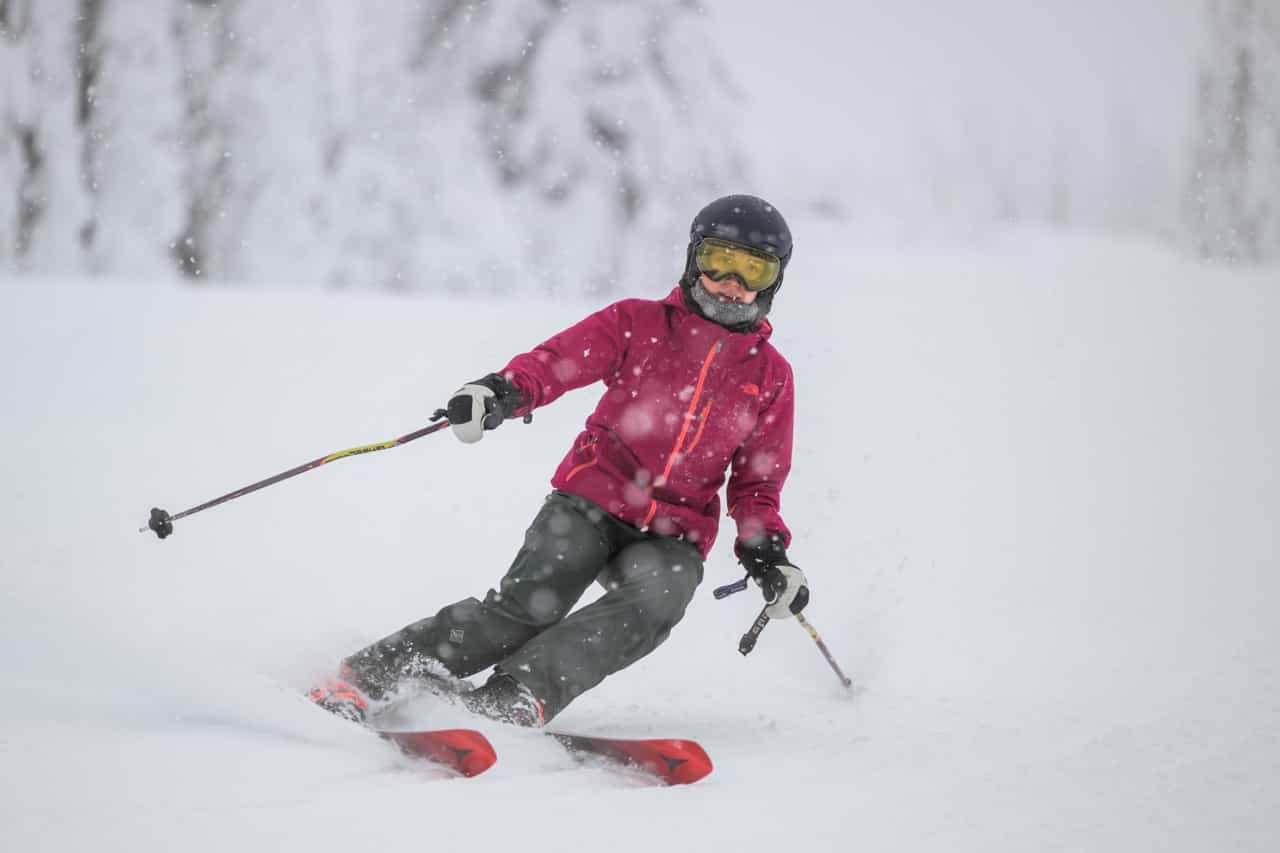 A skier making turns in snow on opening day at Big White Ski Resort