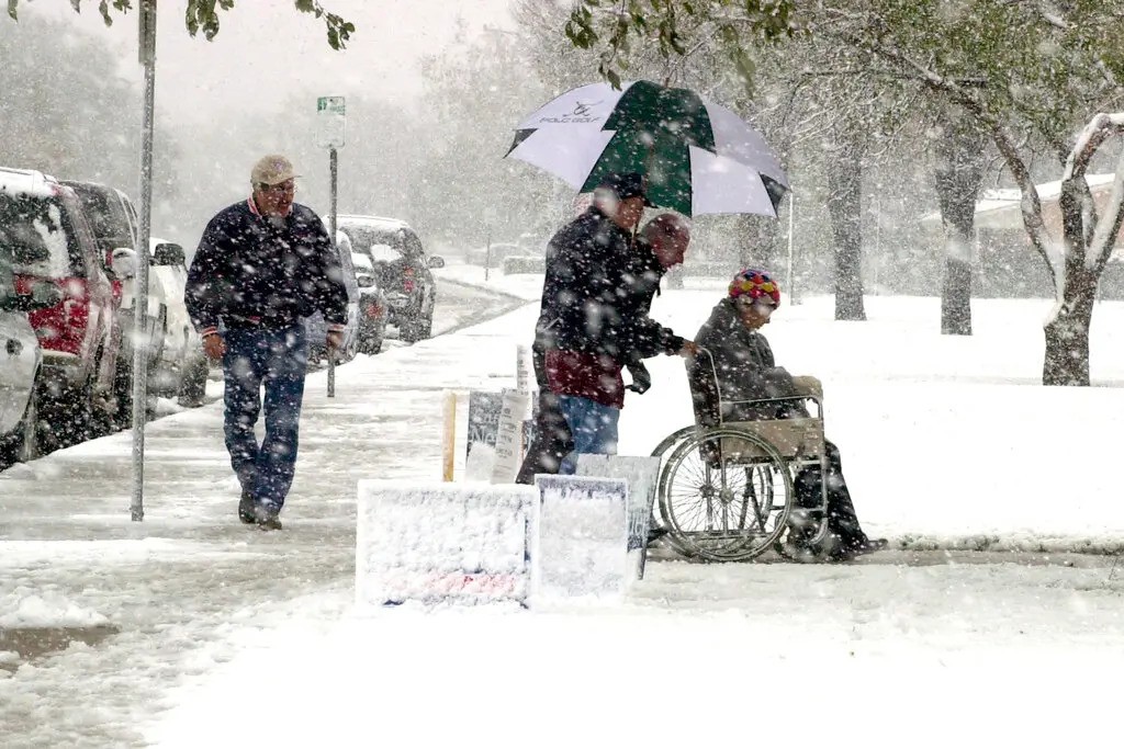 Man in wheel chair in storm, going to vote