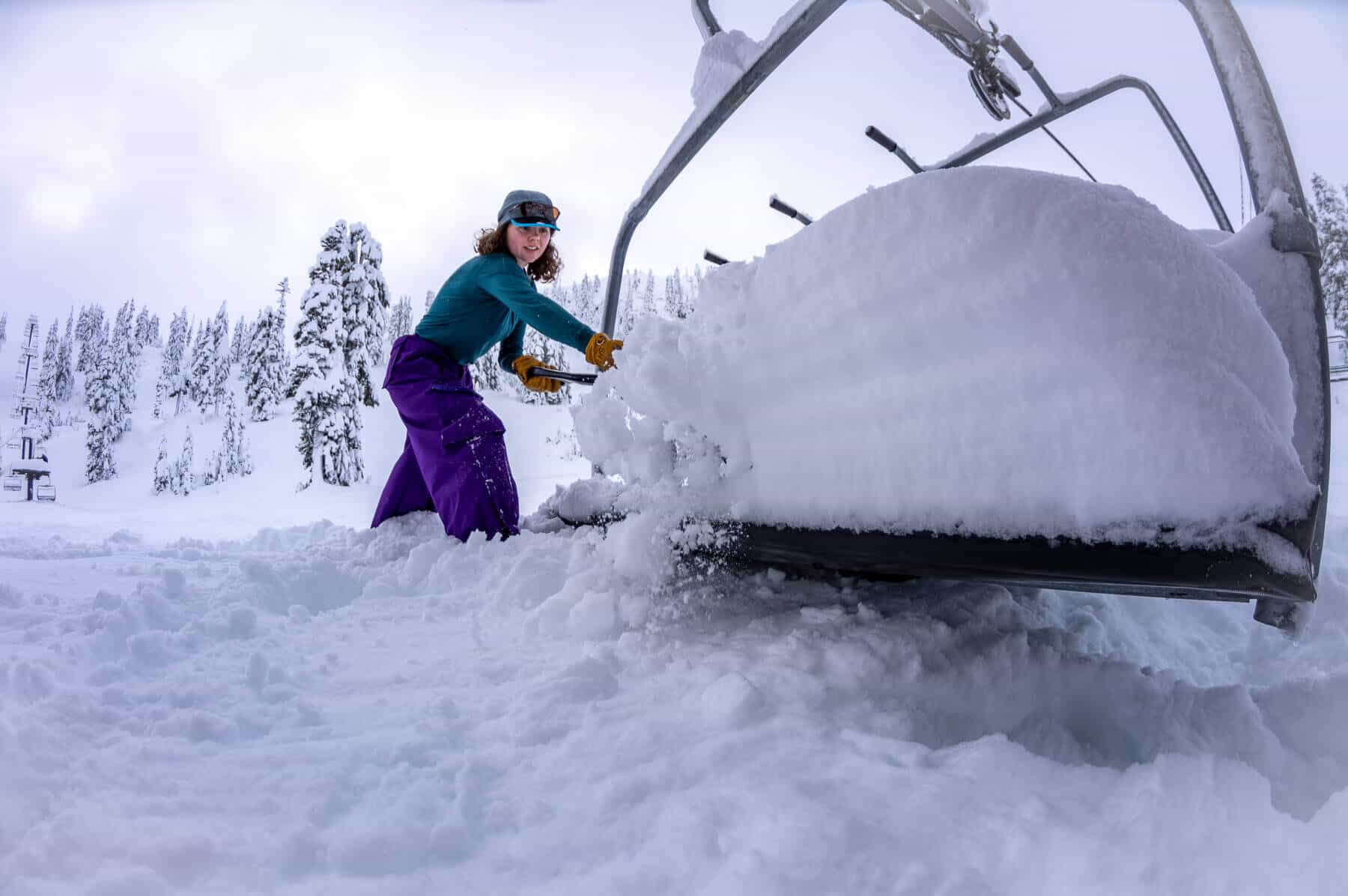 Lifty clearing feet of snow off chairlift at mount baker ahead of early opening